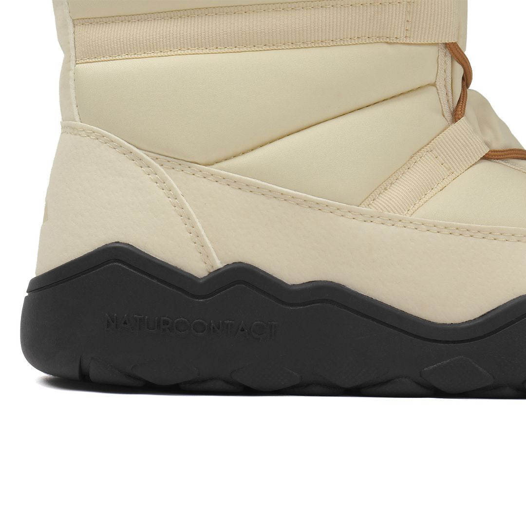 Close-up of a beige winter boot with a black sole on a white background
