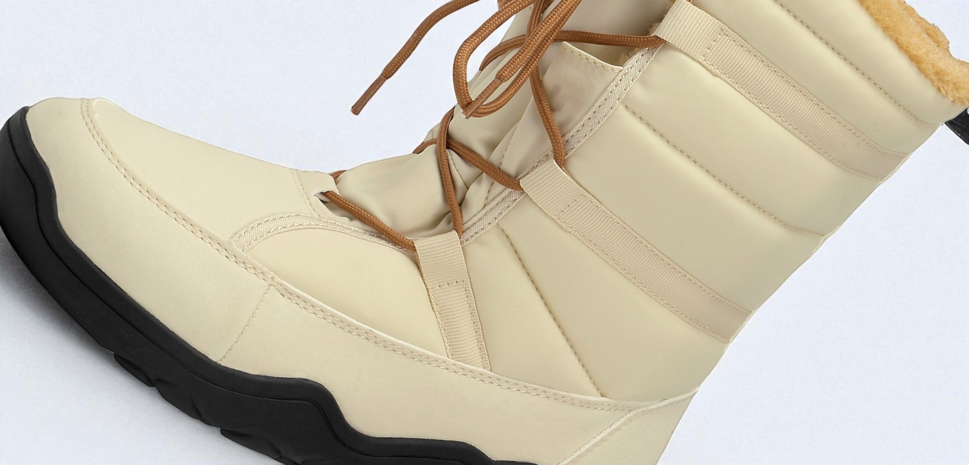 Beige winter boot with brown laces on a white background