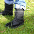 IClose-up of black Naturcontact Lapland winter barefoot boots with laces, worn outdoors on a grassy surface.