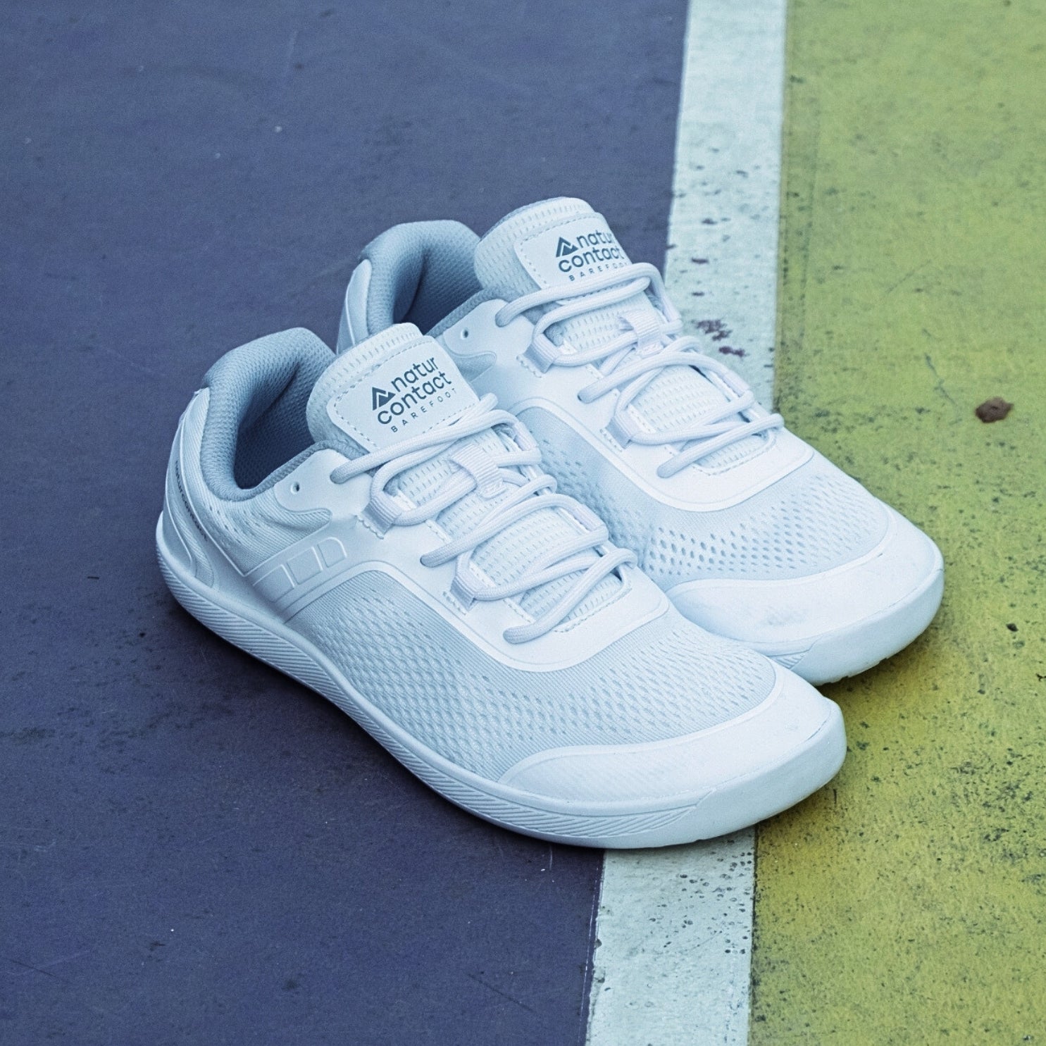 white athletic shoes on a tennis court