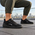 Black Naturcontact Aramid Contact 2.0 barefoot trainers worn with olive trousers outdoors in an urban rooftop setting.