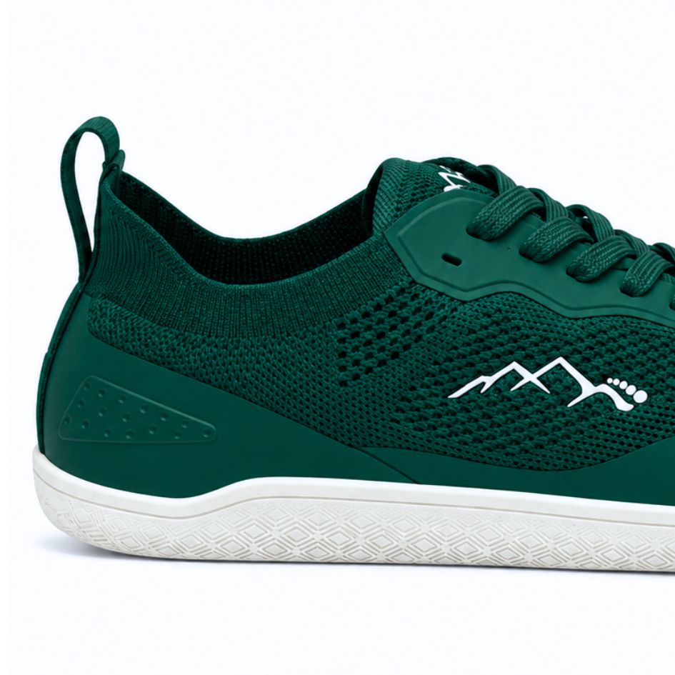 Close-up of the heel and side of forest green Aramid Contact 2.0 barefoot trainers showing the knit texture, heel pull loop and mountain logo.