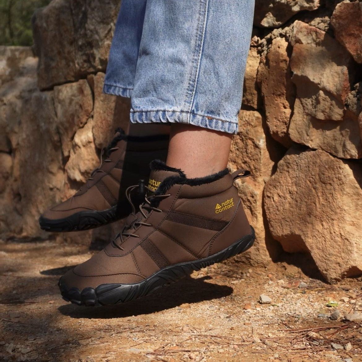 Naturcontact Arctic Contact 4.0 brown barefoot winter boots worn outdoors on rocky trail with flexible sole