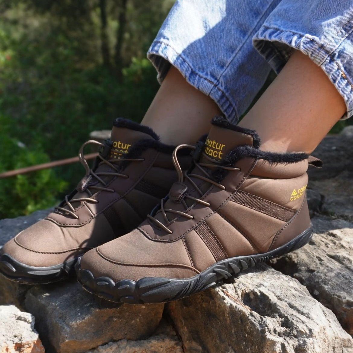 Naturcontact Arctic Contact 4.0 brown barefoot winter boots worn on rocky terrain, flexible sole and warm lining visible