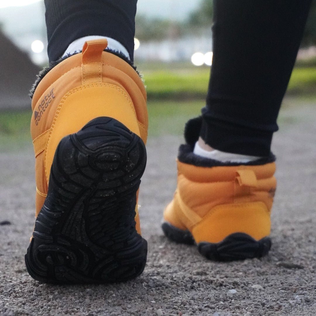 Naturcontact Arctic Contact 4.0 yellow barefoot winter boots worn outdoors showing flexible sole while walking