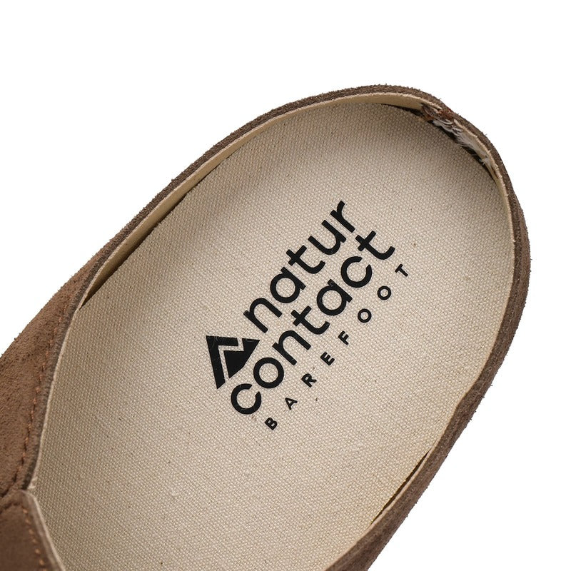 Close-up of a barefoot suede clog sole with 'natur contact barefoot' logo on a white background