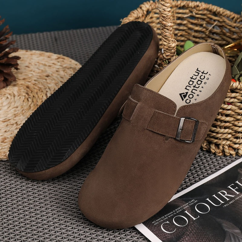 Brown barefoot suede clog with a buckle on a textured surface, featuring the Natur Contact brand.