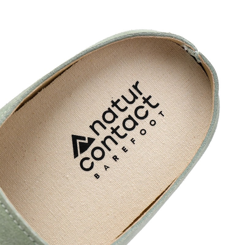 Close-up of a barefoot suede clog insole with 'natur contact barefoot' branding on a white background