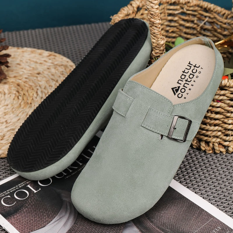 Green barefoot suede clog with a buckle on a textured surface, featuring the 'natur contact' brand.