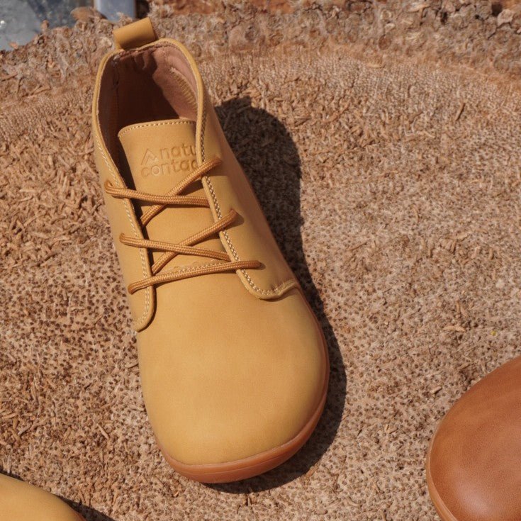 Top view of Naturcontact George Smart barefoot shoes in tan vegan leather worn outdoors on stone surface