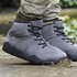 Naturcontact Intemperia winter barefoot boots in Grey, worn outdoors on stone ground, showing the flexible zero-drop sole, wide toe box, and natural ankle support.