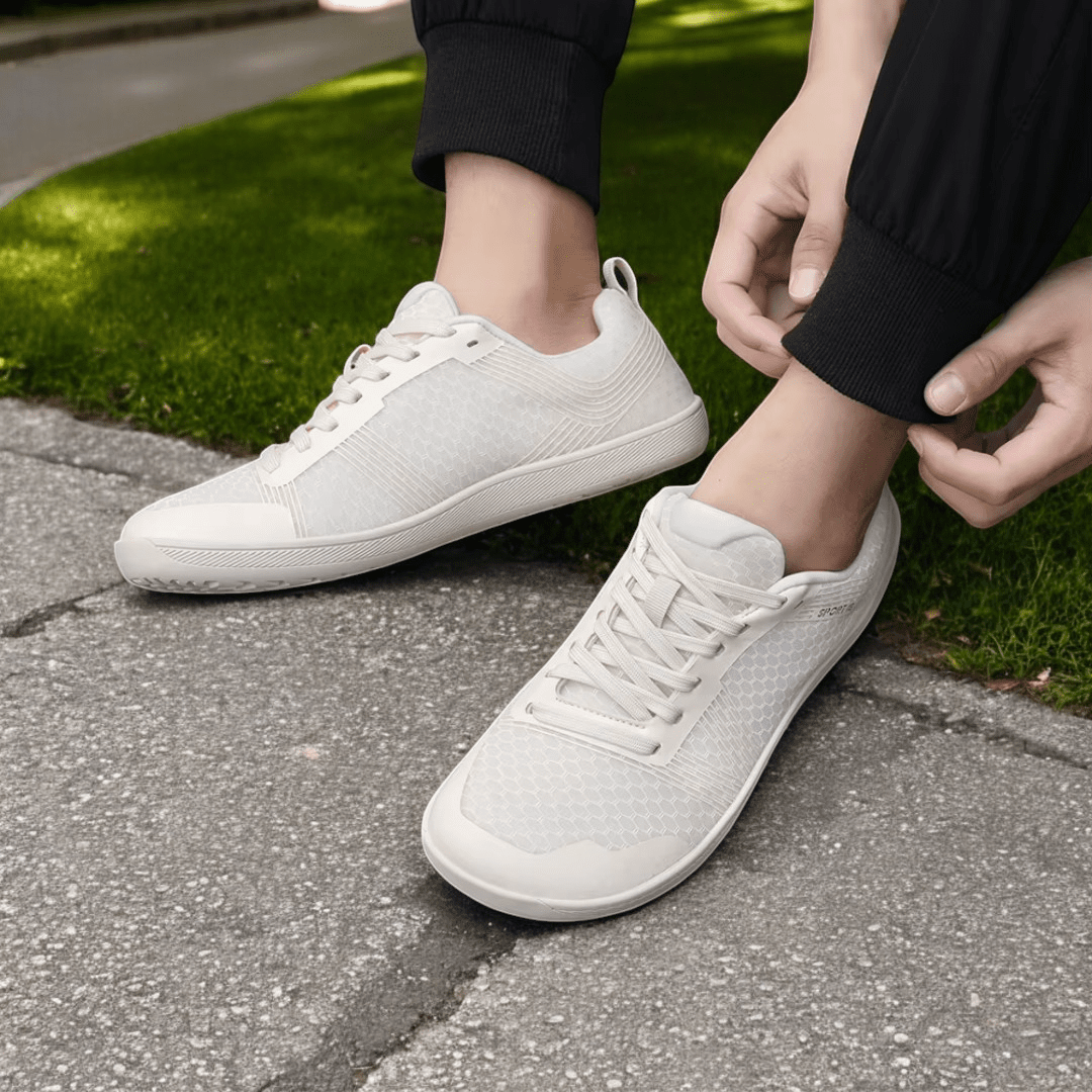 Person wearing Naturcontact Metro Flex 2.0 white barefoot shoes while walking on an urban sidewalk