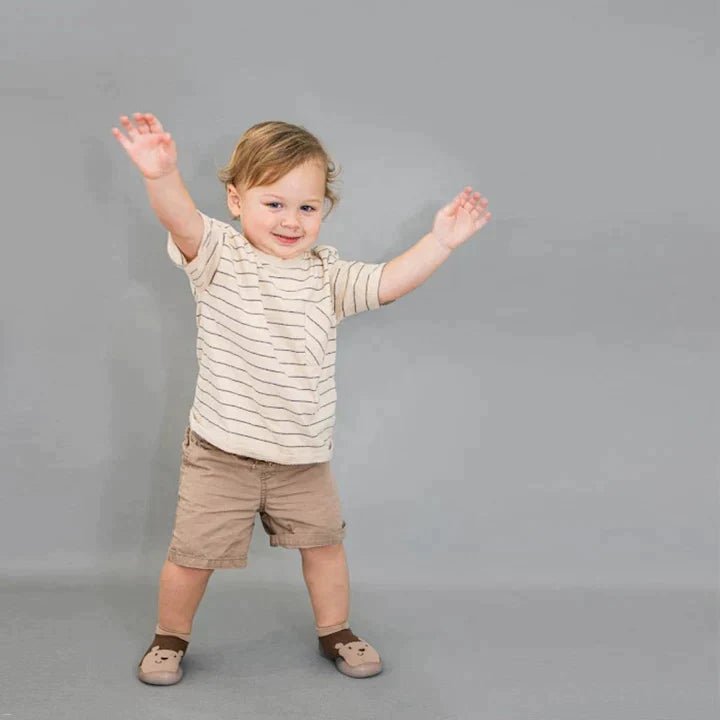Naturcontact Mini Contact 2.0 baby barefoot shoes worn by toddler taking first steps, flexible sock-style design supporting balance, stability and natural foot development.