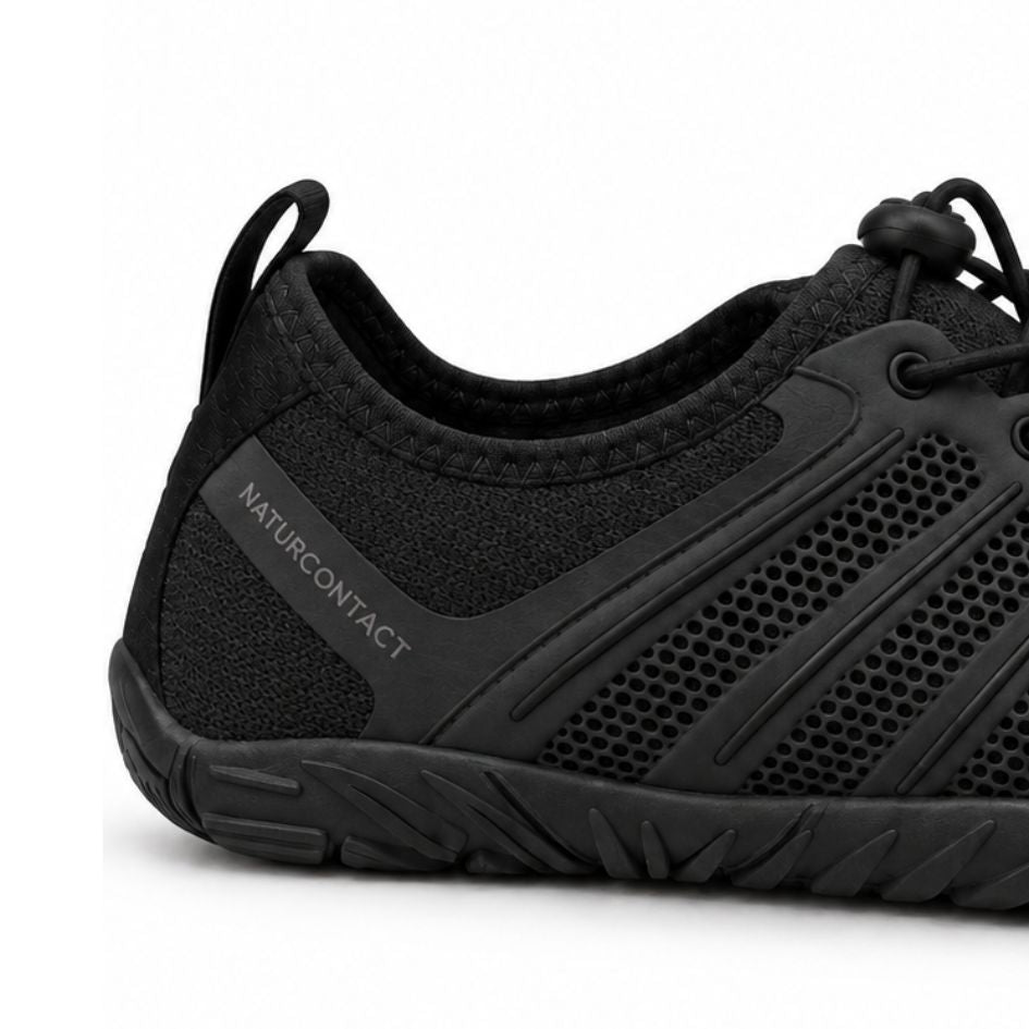 Heel close-up of black Naturcontact Sport Contact 2.0 shoes showing the brand detail, mesh upper and sculpted outsole.