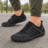 All-black Sport Contact 2.0 barefoot trainers worn with olive trousers outdoors, showing the low-profile minimalist design.