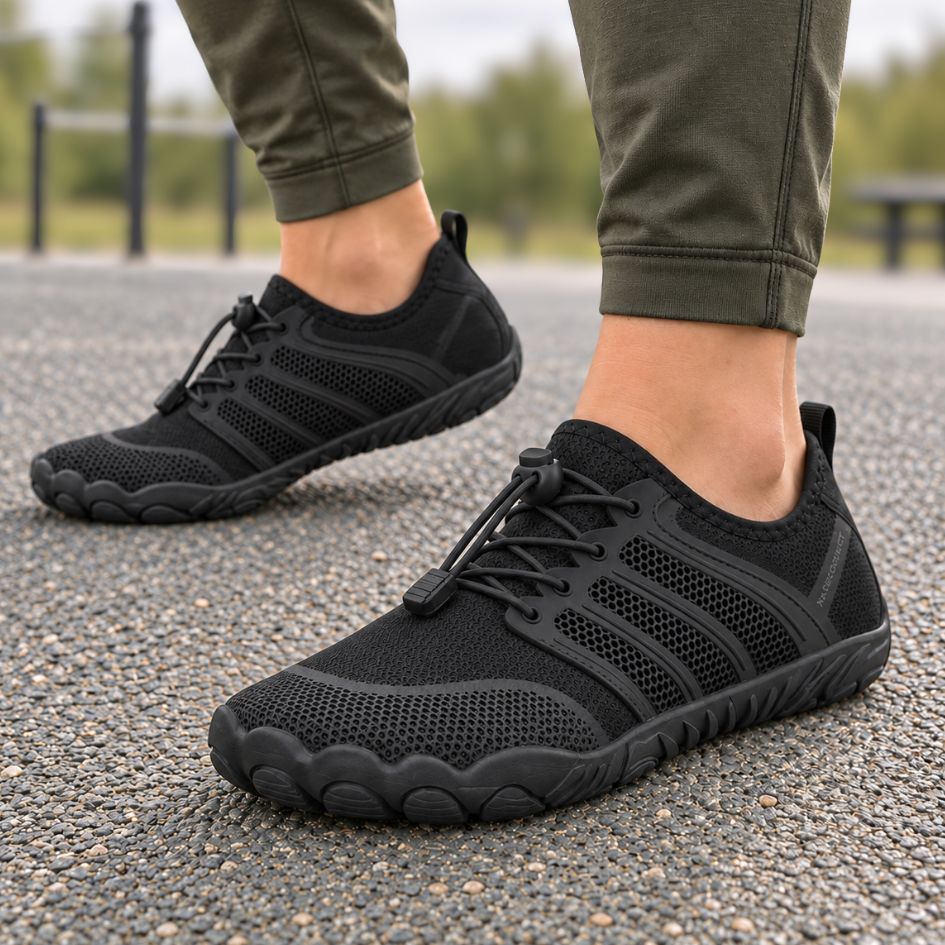All-black Sport Contact 2.0 barefoot trainers worn with olive trousers outdoors, showing the low-profile minimalist design.