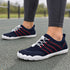 Navy blue and red Naturcontact Sport Contact 2.0 barefoot trainers worn with dark leggings outdoors, showing the flexible low-profile design.