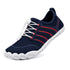 Three-quarter view of Naturcontact Sport Contact 2.0 barefoot trainers in navy blue with red side accents, white elastic quick-laces and a flexible white outsole.