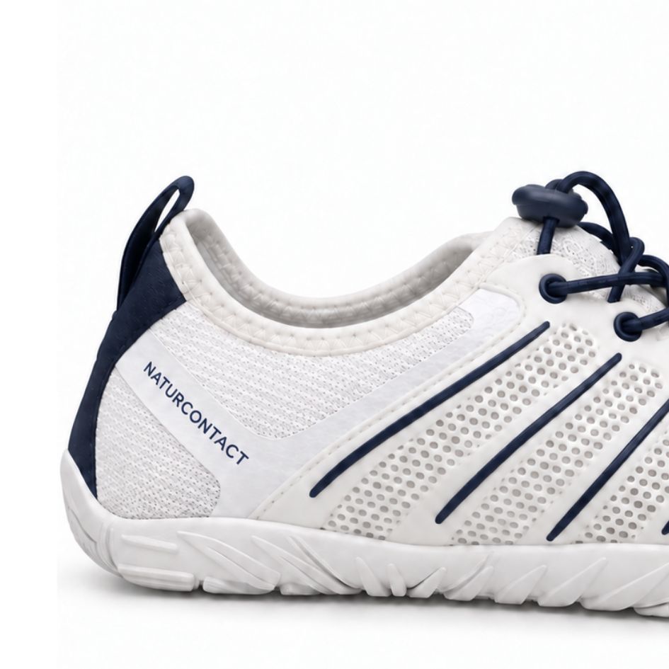 Heel detail of white and navy Naturcontact Sport Contact 2.0 showing side branding, dark blue accents and sculpted sole.