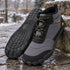 Pair of grey Storm Feel shoes on a wet winter path with patches of snow in the background.