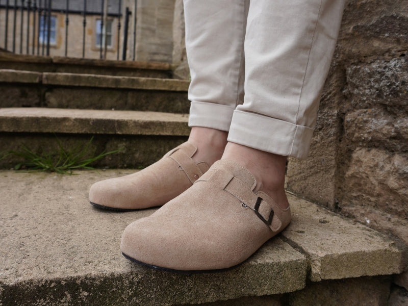 Comfortable tan barefoot mules paired with light trousers for a casual outdoor look.