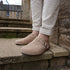Comfortable tan barefoot mules paired with light trousers for a casual outdoor look.