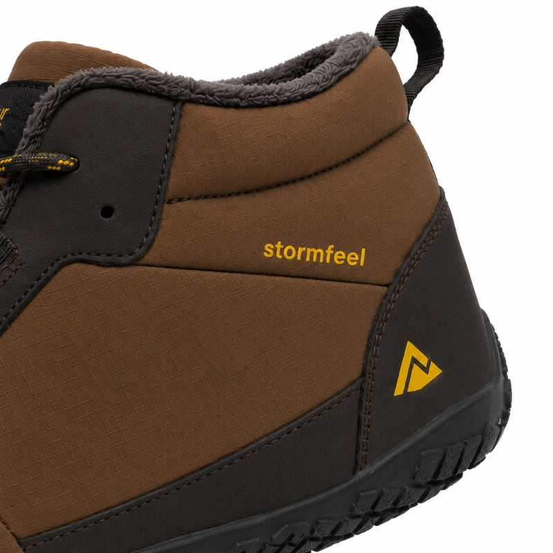 A close-up of a brown and black mid-height work boot with a gray fleece lining, featuring the yellow 'stormfeel' brand name on the side.