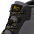 Close-up of a dark gray and black winter boot with yellow accents, featuring a black tongue label with the 'natur contact BAREFOOT' logo and yellow laces.