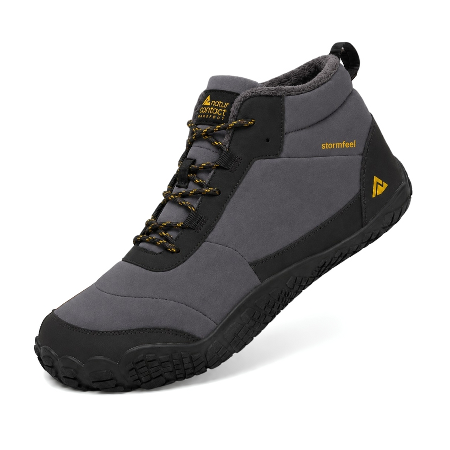 A mid-cut waterproof hiking boot in gray and black with yellow accents, featuring a soft fleece lining and a rugged sole, shown on a white background.