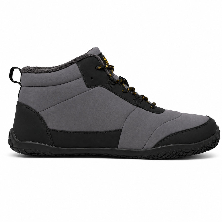 A mid-top waterproof shoe in gray and black, featuring a textured black sole, black laces, and a small yellow logo on the tongue, shown against a plain white background.