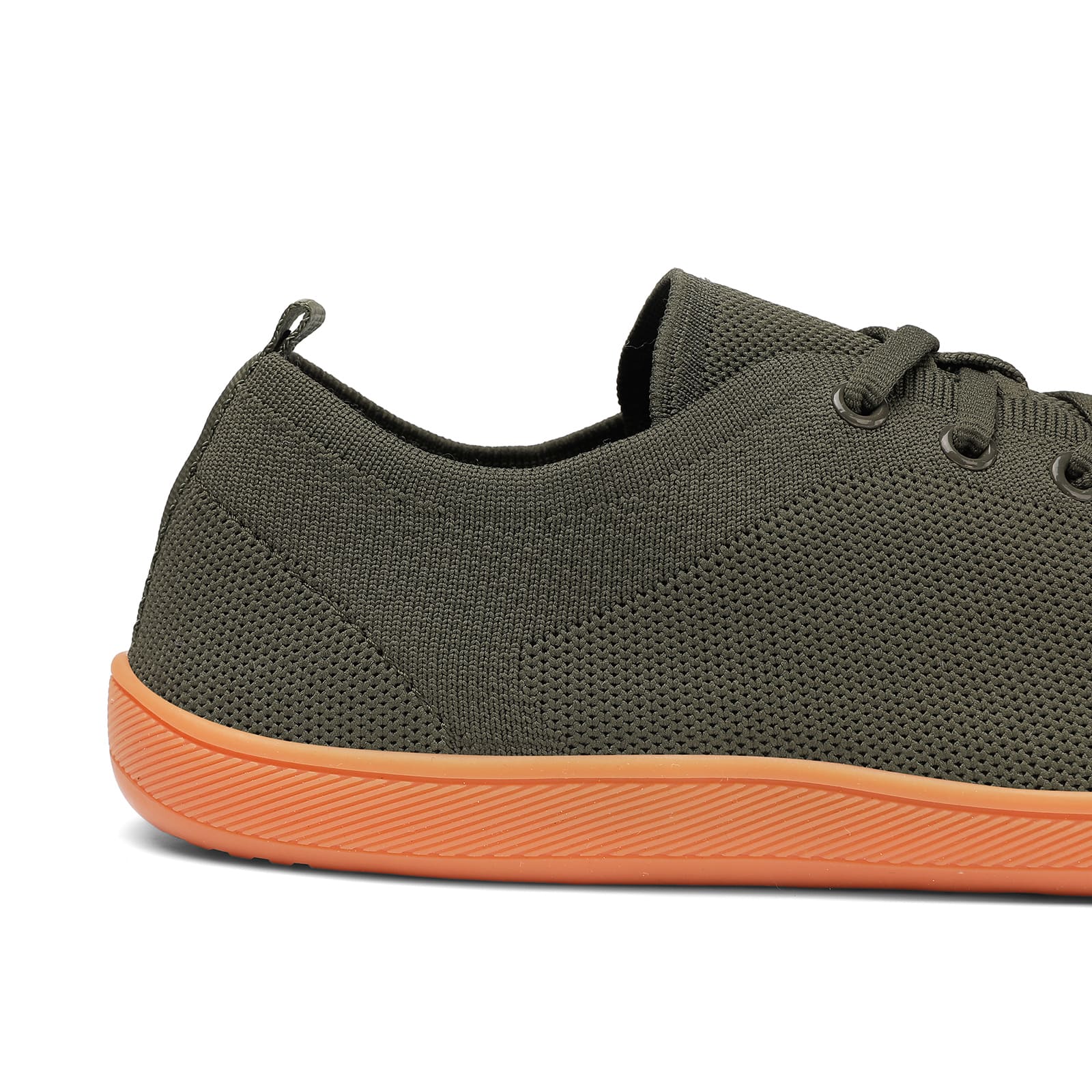 Dark gray sneaker with orange sole on a white background