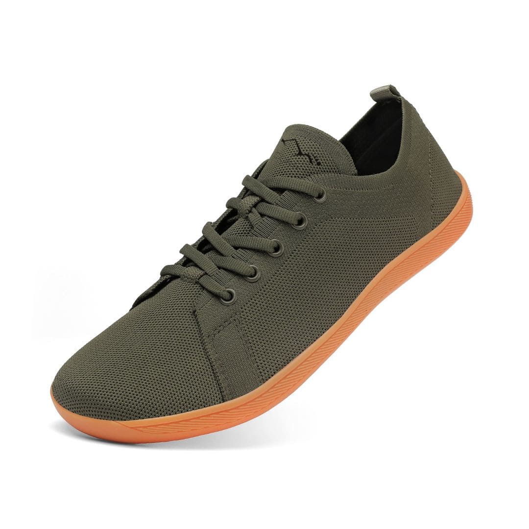 Green sneaker with orange sole on a white background