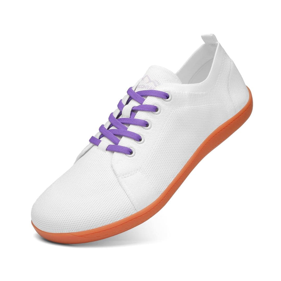 White sneaker with purple laces and orange sole on a white background