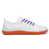 White sneaker with purple laces and orange sole on a white background